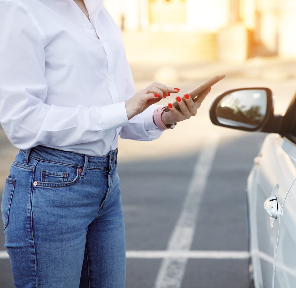 Whitney leaning against a railing on a downtown street